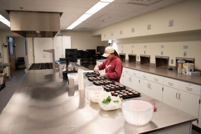 student working in kitchen going through ingredients