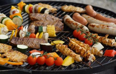 Various cuts of meat and veggies on a grill