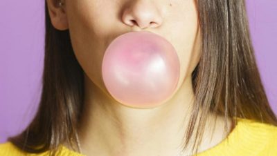 A person blowing a bubble with bubblegum