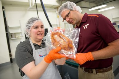 Two people inspect a package of food