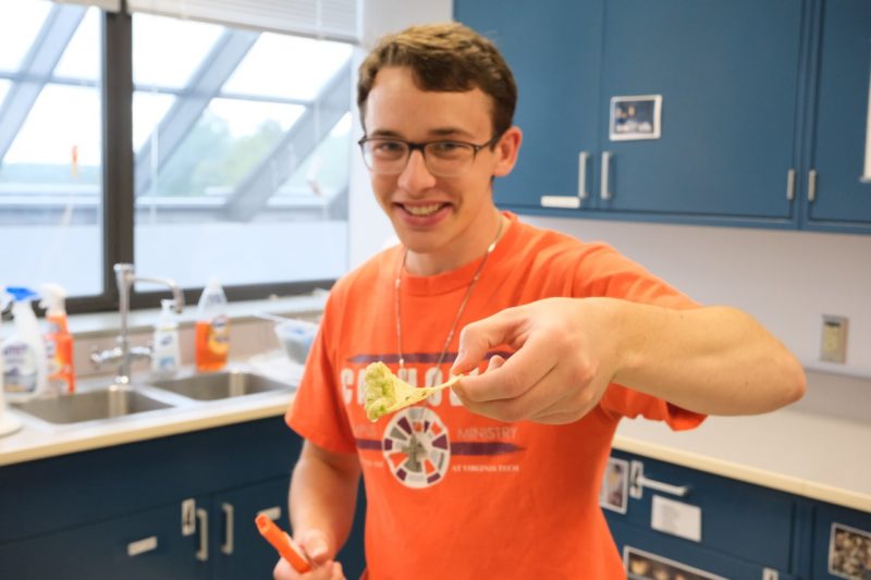 A student displays the salsa he made in class while studying food safety