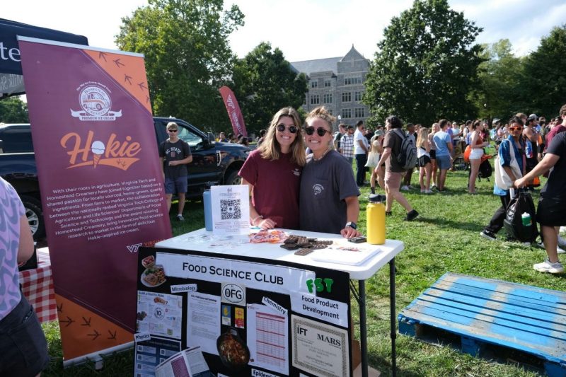 Students in the Food Science Club pose with their poster and booth during Gobblerfest.