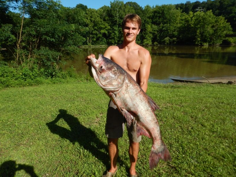 A student holds up a fish