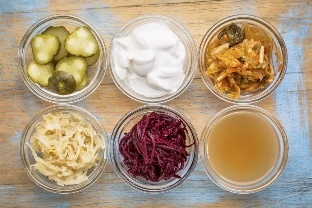 6 bowls of fermented foods on a wood table
